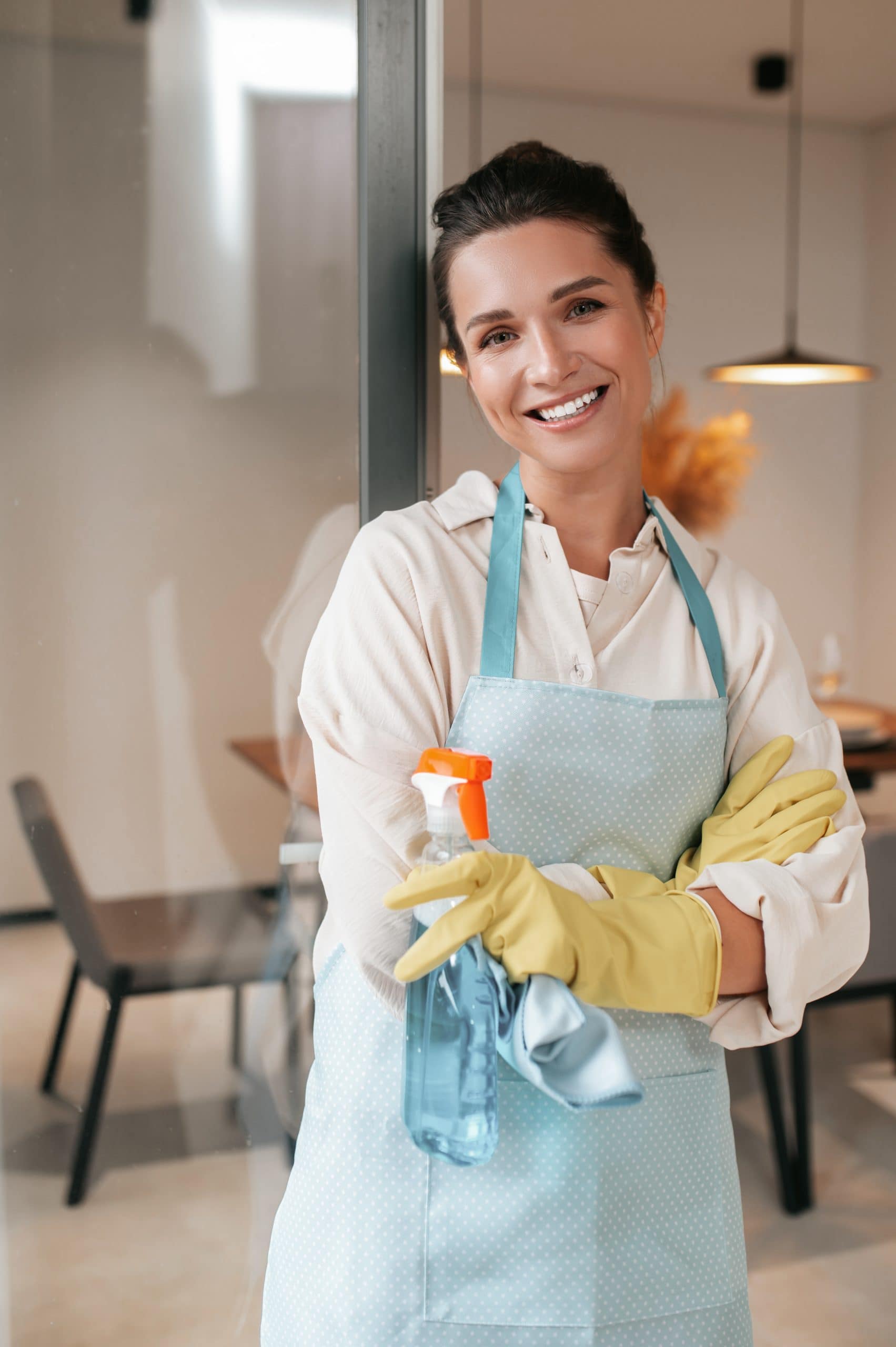 smiling housewife in apron standing in the kitchen